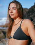 JAYD model Cass wearing the Kiama bikini swim top on the beach, a popular triangle style classic that is practical, stylish and functional.