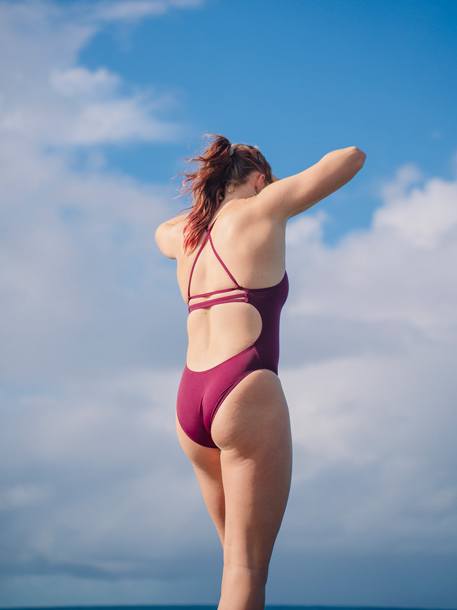JAYD Swimwear model wearing the full coverage, Airlie one piece swimsuit in sangria.