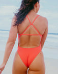 JAYD Model Madi wearing the cheeky coverage Albi one piece swimsuit in Blaze red with a fixed-back triangle design for optimal support and security.