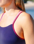 Close up of the contrasting Acai Apsley one piece swimsuit with Sangria and fairy floss pink double shoulder straps.
