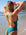 JAYD Swimwear model standing on a beach seen from behind wearing the Cove Finley one-piece swimsuit with bright green Moss fixed