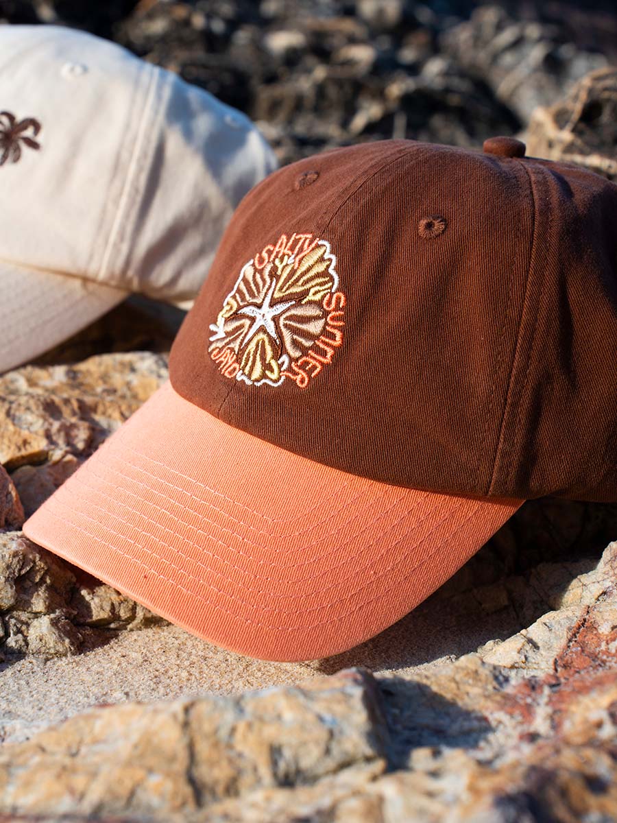JAYD Swimwear Brown &amp; Apricot Baseball Cap sitting on a rock.