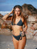 JAYD model Cass walking on a beach listening to a vintage music player, wearing the Kiama bikini top in Carbon grey with matching Carbon bottoms.