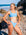 JAYD Swimwear model Chloe standing on a rocky beach with the ocean in the distance, wearing the Nalu Bikini Top in Breeze blue.