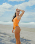 JAYD model Charlotte showcasing the cheeky  high-cut hip design of the Zimmy one piece in Flare orange, which elongates the legs and creates a long, lean silhouette so you can dive in with confidence and finesse.