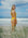 Surf Life Saving athlete Brodee standing on a grassy beach wearing the JAYD Zimmy one piece in Ignite yellow.